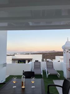 a patio with a table with wine glasses on it at Casa Picacho in Tinajo