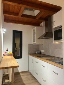 a kitchen with white cabinets and a wooden table at Casa Picacho in Tinajo
