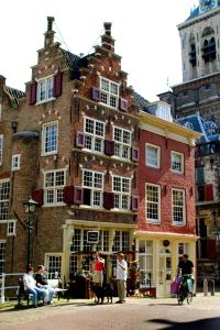 people are walking down the street in front of a brick building at Best Western Museumhotels Delft in Delft