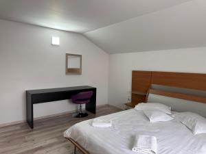 a bedroom with a bed and a desk and a desk at Casa Valentino in Buşteni