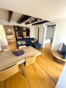 a living room with a table and a couch at Duplex Le Léonor in Strasbourg