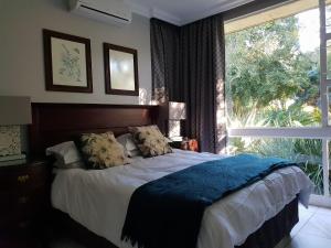 a bedroom with a bed and a large window at Paisley & Pomegranate in Utrecht
