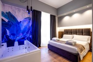 a bedroom with a bed with a blue painting on the wall at Residenze Chamur- Grattacielo in Palermo