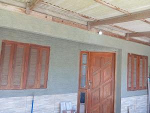 an empty room with two doors and wooden ceilings at Casa na praia do cassino in Rio Grande