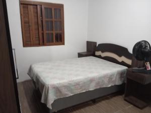 a bedroom with a bed in a room with a window at Casa na praia do cassino in Rio Grande +2 photos
