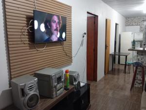 a television hanging on a wall in a living room at Casa na praia do cassino in Rio Grande