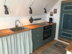 a kitchen with a sink and a counter top at Kornloftet i Lodbjerg in Vestervig
