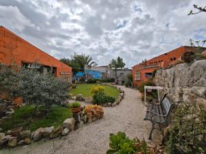 a garden with a bench and a stone wall at B&B Domu Delunas in Giba