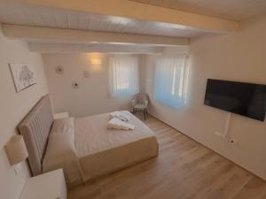 a bedroom with a bed and a flat screen tv at B&B Olea Tarsia in Tarsia
