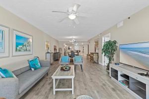 Una sala de estar con un sofá y un televisor de pantalla plana. en DiMucci Tower 201, en Daytona Beach Shores