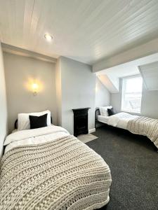 a bedroom with two beds and a fireplace at Luxury 5 bed Salford home free parking in Manchester