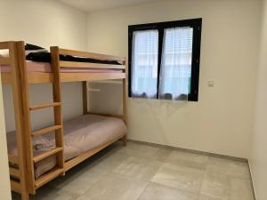 due letti a castello in una stanza con finestra di Maison neuve à la montagne a Le Châtelard