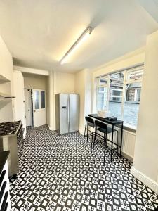 a kitchen with a refrigerator and a table in it at Luxury 5 bed Salford home free parking in Manchester +17 photos