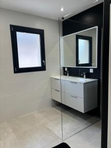 un bagno con lavandino e specchio di Maison neuve à la montagne a Le Châtelard