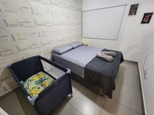 a bedroom with a bed and a white wall at 2 DTS - Bela Vista - espaçoso + aconchegante in Sao Paulo