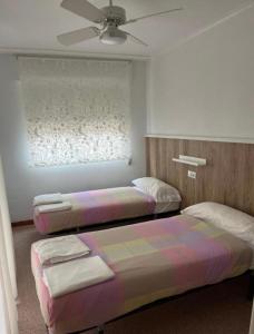 a bedroom with two beds and a ceiling fan at Apartamento CA VALEN 6 in Peniscola