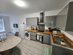 a kitchen with a sink and a stove top oven at Kingdom apartments in Wolverhampton