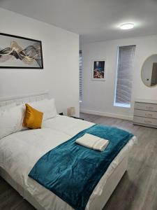 a bedroom with a large bed with a blue blanket on it at Kingdom apartments in Wolverhampton