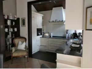 a kitchen with a counter and a chair in a room at Ferienwohnung Schindele am Bodensee in Langenargen +5 photos