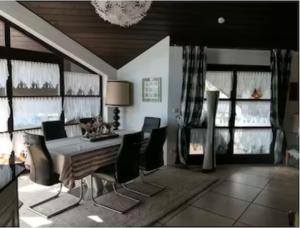 a dining room with a table and chairs and windows at Ferienwohnung Schindele am Bodensee in Langenargen