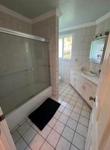 a bathroom with a shower and a tub and a sink at Suburban oasis home in Monterey Park +7 photos