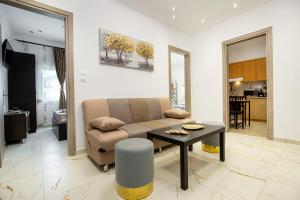 een woonkamer met een bank en een tafel bij Ella Deluxe in Limenaria