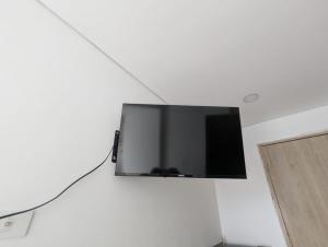 a flat screen tv hanging on a white wall at Aparta Suite Vista al Mar Rodadero in Gaira