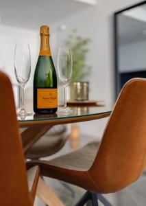 a bottle of wine sitting on a table with two glasses at Benidorm Beach Belluba luxury bay in Benidorm