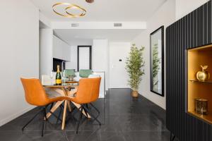 a dining room with a table and orange chairs at Benidorm Beach Belluba luxury bay in Benidorm
