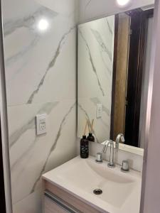 un bagno con lavandino e specchio di Nómada a Villa María