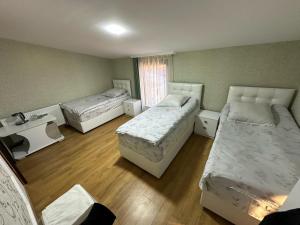 a room with three beds and a window at Family hotel in Gori