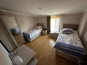 a small room with two beds and a mirror at Family hotel in Gori