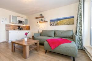 una sala de estar con un sofá y una mesa en Yachthafenresidenz-Wohnung-9303-887, en Kühlungsborn