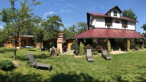a house with chairs on the lawn in front of it at Casa BRA Viștișoara in Stațiunea Climaterică Sâmbăta