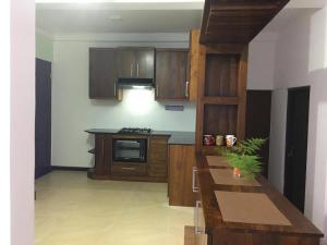 a kitchen with wooden cabinets and a counter top at Galle MK Villa in Galle