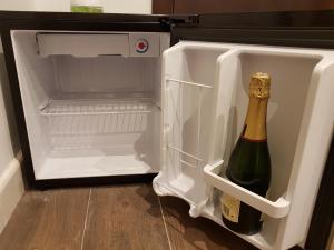 an open refrigerator with a bottle of champagne in it at Hostal del Currante Babilafuente in Babilafuente