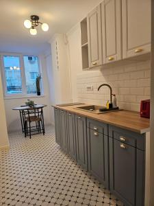a kitchen with a sink and a counter with a table at At Blue in Suceava