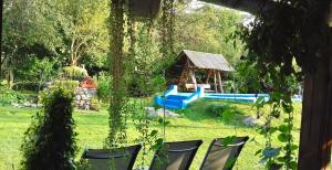 a yard with chairs and a playground in the background at Casa BRA Viștișoara in Stațiunea Climaterică Sâmbăta