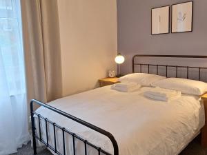 a bedroom with a bed with white sheets and a window at Two-bedroom Cottage - Sandstone Garden Patio - Free Parking - Pets Welcome in Ingrow