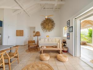 a living room with a couch and a table at Chez Paulette à distance à pied de la plage et piscine chauffée in Friar's Bay