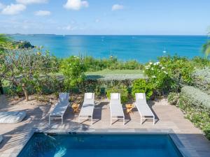 a group of chairs and a swimming pool with the ocean at Chez Paulette à distance à pied de la plage et piscine chauffée in Friar's Bay +47 photos