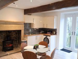 a kitchen with a table and chairs and a fireplace at Two-bedroom Cottage - Sandstone Garden Patio - Free Parking - Pets Welcome in Ingrow
