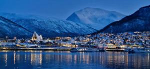 a town on the water with mountains in the background at Koselig leilighet i tur-eventyret Tromsø in Kvaløya +28 photos