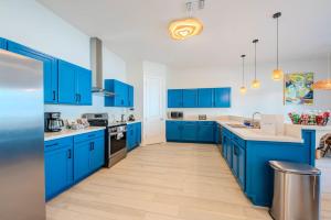 a blue kitchen with white walls and blue cabinets at Starfish Shores in South Padre Island