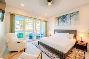 a bedroom with a bed and two chairs and a window at Starfish Shores in South Padre Island