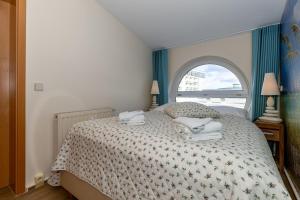 Un dormitorio con una cama con toallas. en Yachthafenresidenz-Wohnung-9303-887, en Kühlungsborn