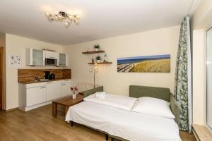 Un dormitorio con una cama y una pequeña cocina. en Yachthafenresidenz-Wohnung-9303-887, en Kühlungsborn 11 fotos más