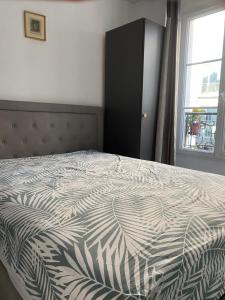 a bedroom with a bed with a black cabinet and a window at Studio au cœur de Montmartre in Paris