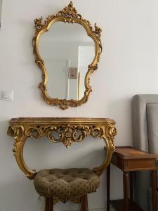 a mirror on a wall next to a table with a stool at Studio au cœur de Montmartre in Paris +11 photos