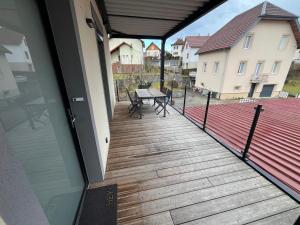a porch with a wooden deck with a picnic table at Appartement Pontarlier-centre in Pontarlier +2 photos